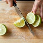 Spicchi di lime tagliati su tagliere.