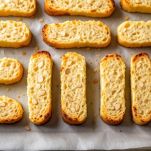 Biscotti disposti su teglia per seconda cottura.