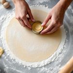 Sfoglia di pasta stesa e coppapasta rotondo.