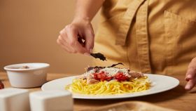 donna decora spaghetti con pomodoro tonno e basilico