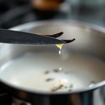 Baccello di vaniglia e bicarbonato aggiunti a latte caldo in pentolino.