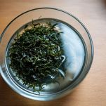 Alghe wakame essiccate immerse in ciotola con acqua.