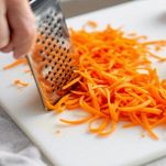 Carote grattugiate a julienne su piano di lavoro.