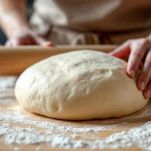 Dischi di impasto dolce tagliati su piano infarinato.
