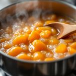 Casseruola con confettura di albicocche in cottura.