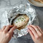 Cartocci di orate chiusi e in cottura nel forno con contorno di patate.