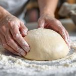 Impasto che lievita coperto con canovaccio in ciotola.