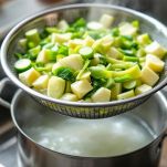 Finocchi scolati e tritati su tagliere.