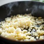 Cipolla tritata che soffrigge in tegame con olio.