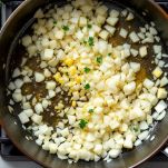 Cipolla e aromi in casseruola che rosolano dolcemente.