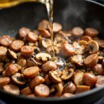 Salsiccia e funghi in rosolatura con sfumatura di vino.