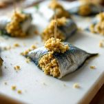 Sarde arrotolate con ripieno e fermate con stecchino.