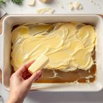 Fontina affettata e teglia unta pronta all’uso.