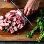 Cubetti di agnello pronti per la cottura con coriandolo pulito.