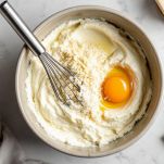 Ricotta e formaggio mescolati in ciotola.