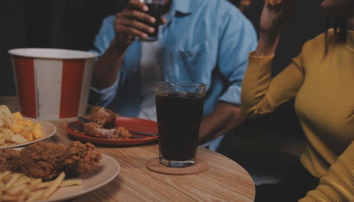 donna mangia e beve in un fast food