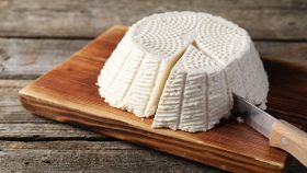 forma di ricotta su tagliere di legno con coltello