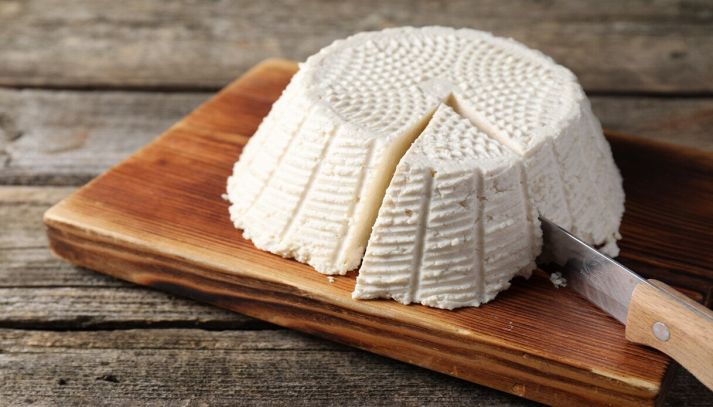 forma di ricotta su tagliere di legno con coltello