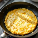 Frittata di vermicelli in cottura in padella antiaderente.