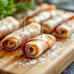 Mani che arrotolano fettine di pollo e fissano con stuzzicadenti.