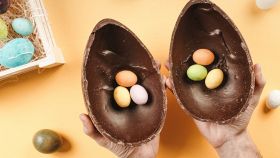 mani che reggono uovo-di cioccolato aperto