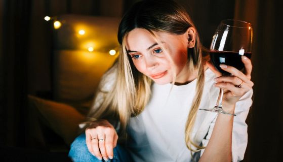 ragazza con bicchiere di vino davanti al pc