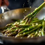 Asparagi in padella durante la cottura.