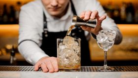 barman con camicia bianca prepara cocktail