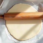 Pasta frolla stesa tra due fogli di carta forno