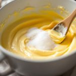 Tuorli d’uovo e burro mescolati in ciotola