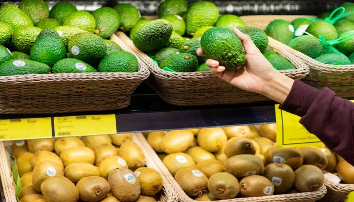 donna al supermercato che compra avocado