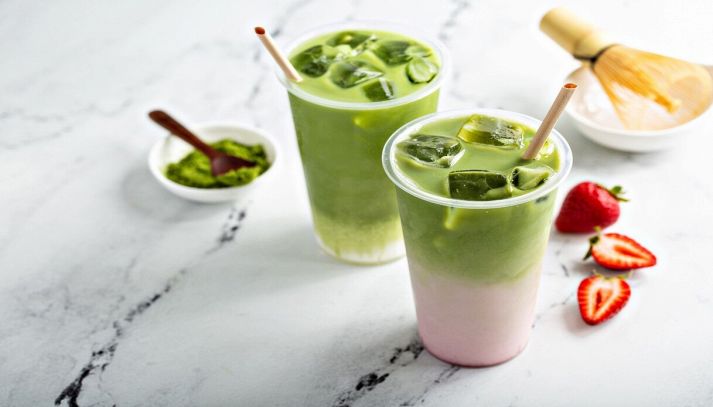 due bicchieri di matcha latte alle fragole su piano di marmo