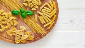 formati di pasta vari su tagliere di legno