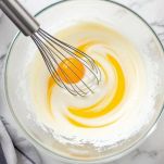 Uovo con zucchero montato in recipiente fino a composto schiumoso