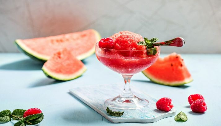 sorbetto all'anguria con fragole e menta su sfondo blu