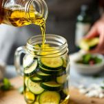 Vasetti con zucchine completamente immerse in olio