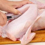 Donna che taglia il pollo