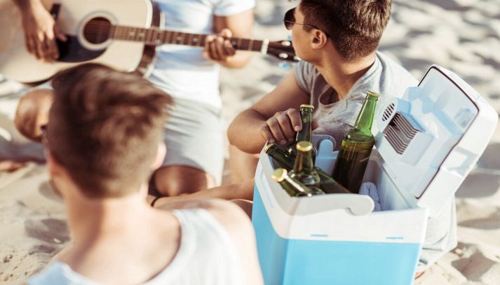 Amici al mare si divertono e bevono birra