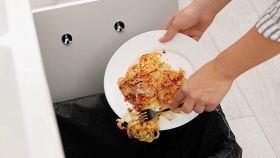 Donna butta piatto di pasta nella spazzatura