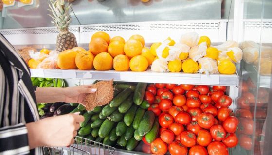 Donna compra noce di cocco al supermercato