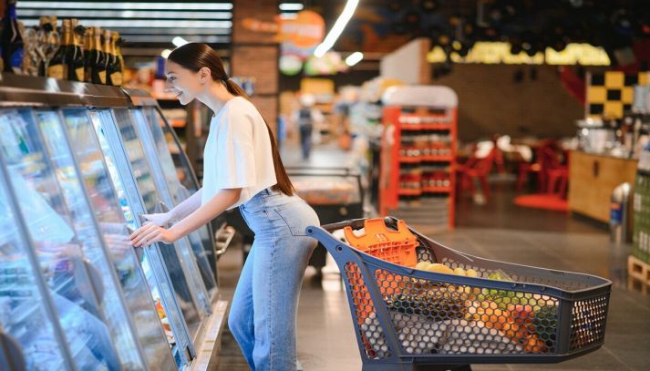 Donna sorridente fa spesa al supermercato