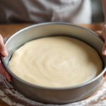 Disco di pasta steso e sistemato in teglia unta