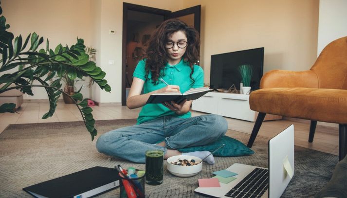 Ragazza concentrata che studia mentre mangia