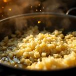 Padella con cipolla che soffrigge in olio e burro