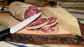 Tagliere di legno con salame e parmigiano