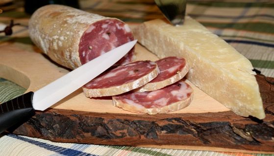 Tagliere di legno con salame e parmigiano