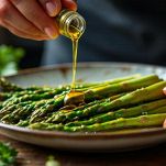 Filo d’olio versato sugli asparagi nella teglia