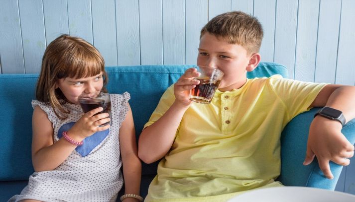 Bambini sorridenti bevono Coca Cola