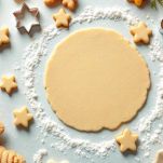 Biscotti ritagliati con stampini sulla teglia.