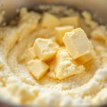 Burro con zucchero e zucchero di canna amalgamati in ciotola